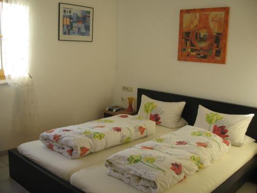 Adelhausen的住宿－堅果樹下公寓，一张带两张床单和枕头的床