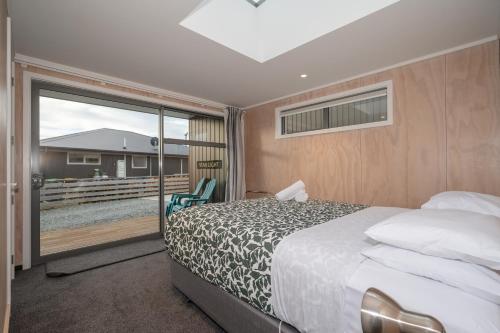 Habitación de hotel con cama y balcón en Starlight Townhouse en Twizel
