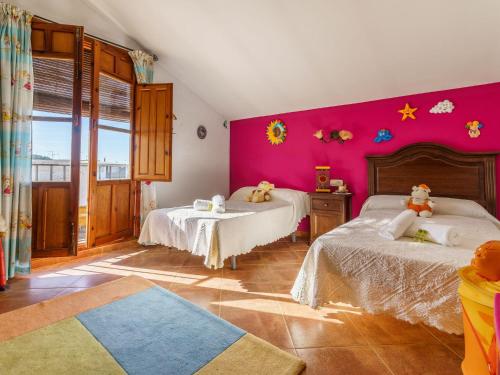 1 dormitorio con 2 camas y pared de color rosa en El Señorio de Alameda, en Alameda