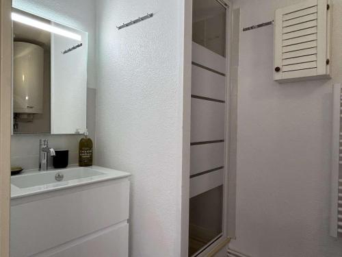 une salle de bain blanche avec un lavabo et un miroir dans l'établissement Appartement studio proche port avec terrasse à Banyuls-sur-Mer - FR-1-225C-122, à Banyuls-sur-Mer