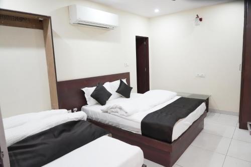 two beds in a hotel room with white and black at Hotel Shree Narayan Palace in Jaipur