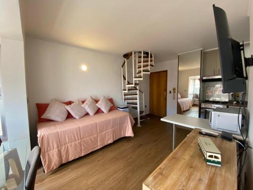 a bedroom with a bed and a desk with a television at Departamento con vista al mar in Viña del Mar