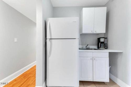 a white refrigerator in a kitchen with white cabinets at Contemporary Zen Place - Entire First Floor in Thousand Oaks