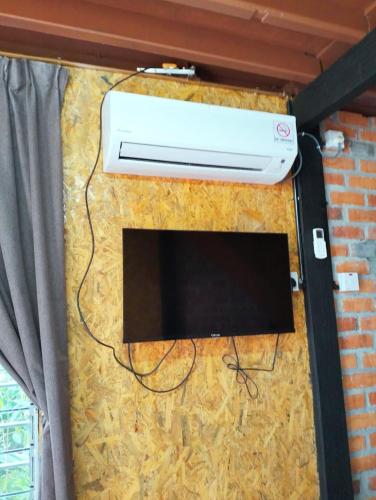 eine Wand mit einer Heizung und einem TV darauf in der Unterkunft CHALET COBEK D' RUMAH BONDA RIVER VIEW in Kampong Senawar