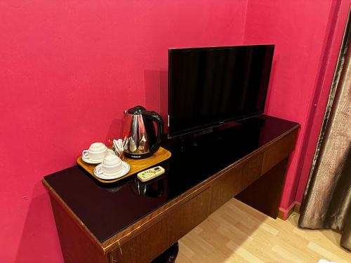 a table with a television and a tea kettle on it at GOA INN HOTEL SDN BHD in Gua Musang