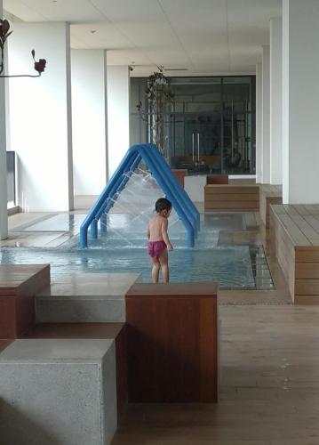 Una bambina in piedi in uno scivolo ad acqua di Luxurious Apartement Lebak Bulus near MRT a Giacarta