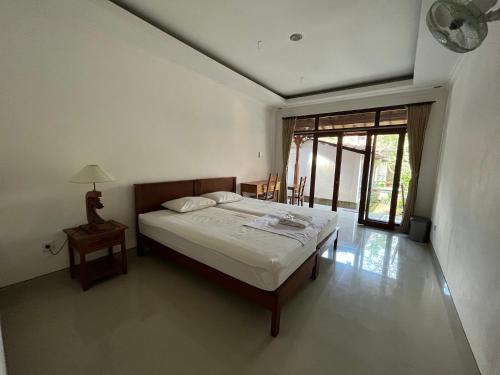 - une chambre avec un lit, une table et une fenêtre dans l'établissement Sujana Homestay, à Ubud