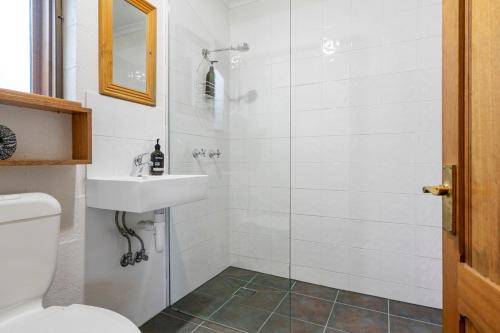 y baño con ducha y lavamanos. en Herons Rise Vineyard Accommodation, en Kettering