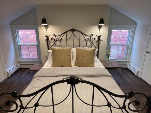 um quarto com uma cama grande e 2 janelas em BEAUTIFUL 3 BDRM HERITAGE HOME-MINS TO DOWNTOWN em Hamilton