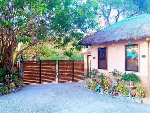 a small house with a fence and a yard at CRISTINA Beachfront Cottages in San Juan