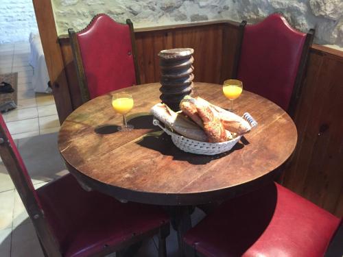 a wooden table with two glasses of wine and food on it at La Vendange Family Gites in Gibourne