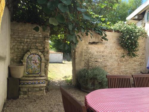 a patio with a table and a brick wall at La Vendange Family Gites in Gibourne