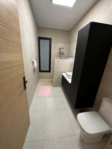 een badkamer met een toilet, een wastafel en een spiegel bij La KAZA-De-LINE in Saint-Joseph