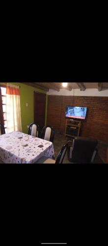 um quarto com uma mesa e cadeiras e uma televisão em LOS NIETOS em Malargüe