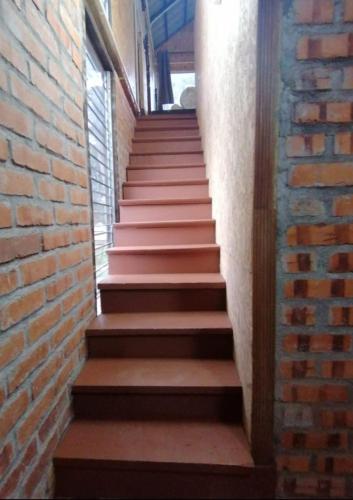 a stairway with a brick wall and brown steps at CHALET MADU KACA D'RUMAH BONDA RIVER VIEW Kuala Kangsar in Kampong Senawar