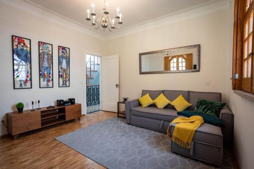 sala de estar con sofá y espejo en CASA BORIS: Insta-worthy fully equipped apartment., en Ciudad de México