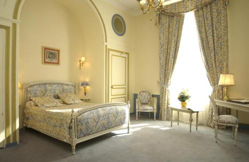 a bedroom with a bed and a window at Malouinière Le Valmarin in Saint Malo