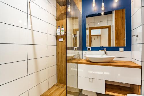 W łazience znajduje się umywalka i lustro. w obiekcie Apartament Yacht Park Marina w mieście Gdynia