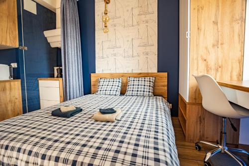 sypialnia z łóżkiem z kocem szachowym w obiekcie Apartament Yacht Park Marina w mieście Gdynia