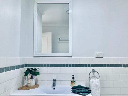 een witte badkamer met een wastafel en een spiegel bij Relax on Riddoch in Penola