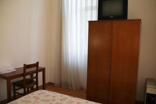 1 dormitorio con TV en la parte superior de un armario de madera en Xango, en Oporto