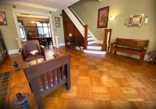 a living room with a wooden floor and stairs at Spacious Bedroom in a Brooklyn House Shared with Host in Brooklyn