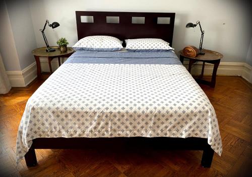 a bedroom with a large bed with two side tables at Spacious Bedroom in a Brooklyn House Shared with Host in Brooklyn