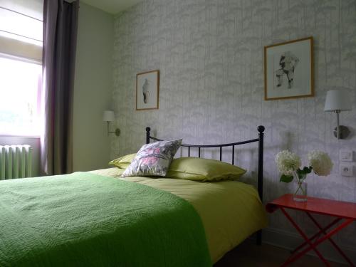 1 dormitorio con 1 cama con edredón verde en Un gîte dans la vallée, en Obersteinbach