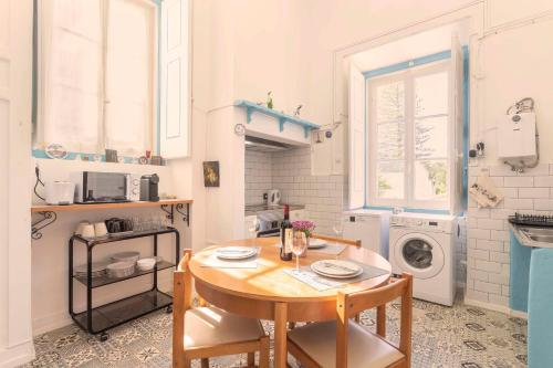 a small kitchen with a table and a washing machine at Happy Holiday Sintra in Sintra