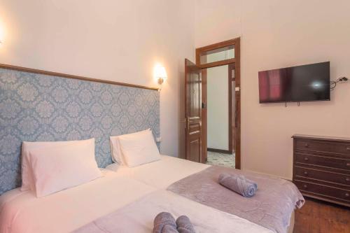 a bedroom with a bed with two slippers on it at Happy Holiday Sintra in Sintra