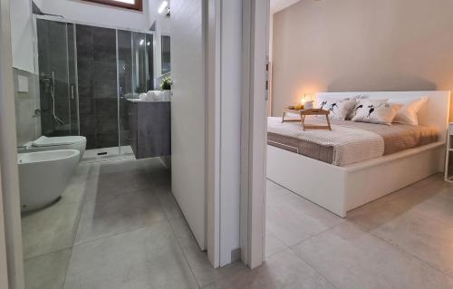 - une chambre avec un lit et une salle de bains pourvue d'une baignoire dans l'établissement Best House Assemini, à Assemini