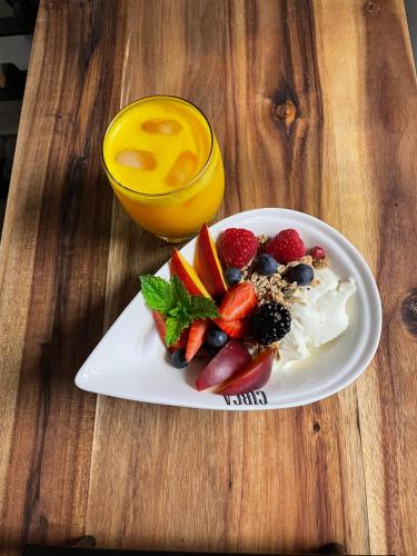 a plate of fruit and a glass of orange juice at CIRCA 1936 Art Hotel in Corowa