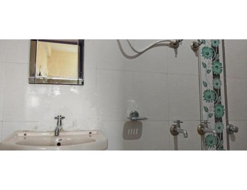 een badkamer met een wastafel en een douche bij Hotel Amandeep Galaxy, Barkot in Barkot