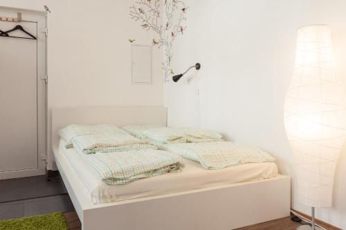 a white bed with two pillows on top of it at Ferienwohnung Holzstraße in Fürth