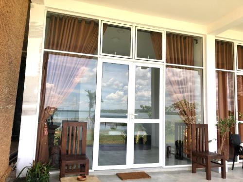 a large window with a view of the ocean at Lapwing Lake Villa in Tissamaharama