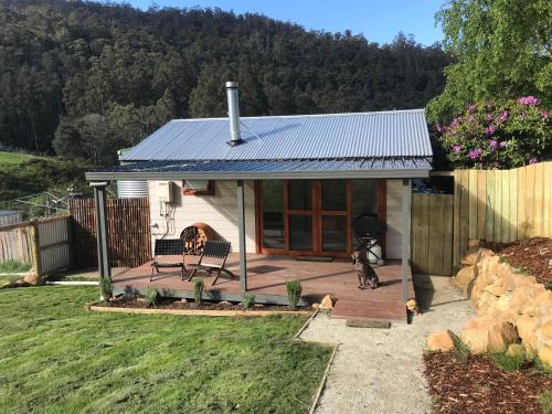 een klein huis met een hond die er voor staat bij Hopkins Homestead Farm Stay Studio in Kettering