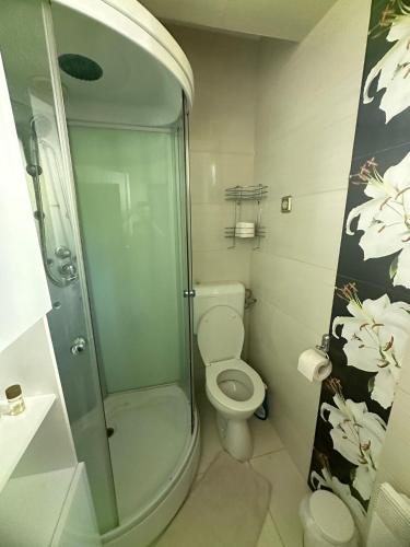 a bathroom with a toilet and a glass shower at Casa Day&Amy in Eforie Sud