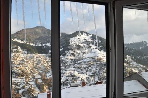 a view of a snowy city from a window at Cozy Loft with Fireplace & View in Metsovo