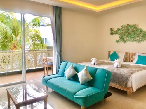 ein Schlafzimmer mit einem Bett und einem Sofa sowie einem Balkon in der Unterkunft Ocean Star Apartment Sanur in Sanur