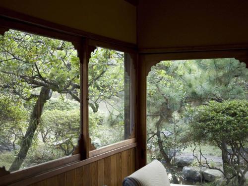 two windows in a room with a view of trees at Numazu Club in Numazu