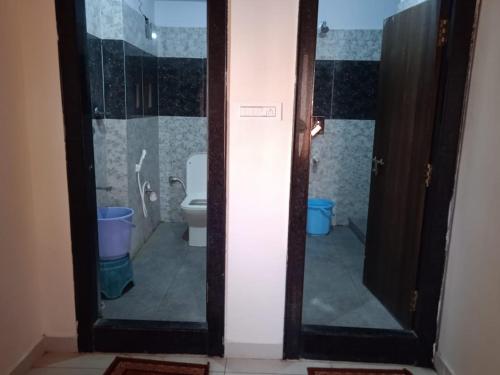 uma casa de banho com um WC e uma porta de vidro em SRI BHAVYARESIDENCY em Bhadrachalam
