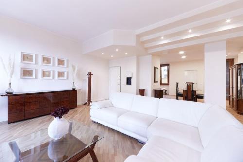 a white living room with a white couch and a table at Elegant Apartment in Milan