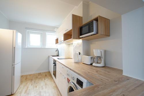 een keuken met een magnetron, een wasmachine en een droger bij Papli Beach Apartment in Pärnu