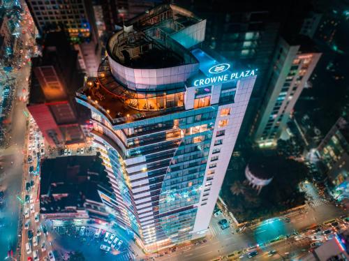 a tall building with a sign on it at night at Crowne Plaza Dhaka Gulshan, an IHG Hotel in Dhaka