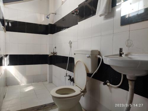 a bathroom with a toilet and a sink at Max Guest House in Agra