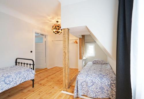 a bedroom with two beds and a staircase at Papli Beach Apartment in Pärnu