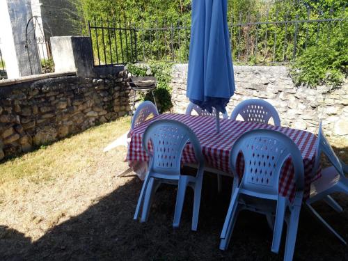 a table and chairs with a table and an umbrella at La Vendange Family Gites in Gibourne