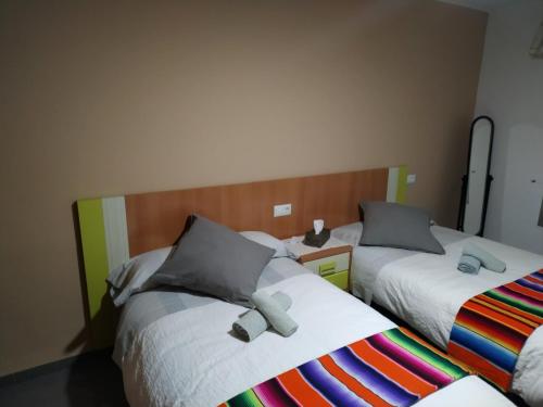 dos camas sentadas una al lado de la otra en una habitación en Bonito apartament a 3 minutos de la playa, en Cullera