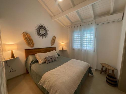 a bedroom with a bed and a window at Mahi-Mahi Lodge, piscine privee, orient bay in Orient Bay French St Martin