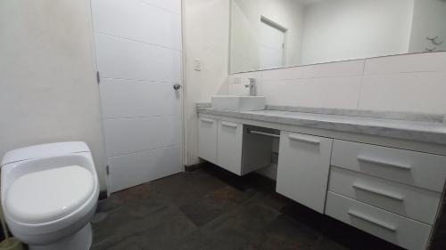 Baño blanco con aseo y lavamanos en Apartment 4 Rent - Av San Borja Norte Cdra 8, en Lima